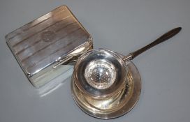 A silver cigarette box, a silver tea strainer and a small silver dish.