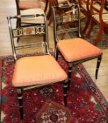 A pair of Regency design ebonised and gilt cane seated dining chairs with squab cushions