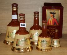 A collection of graduated Bells Scotch Whisky and a bottle of Hennessy Cognac