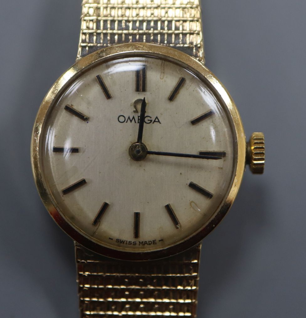 A lady's 9ct gold Omega manual wind wrist watch, on a 9ct gold Omega strap.