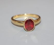 A modern 18ct gold and oval cut garnet ring, size N.