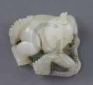 A Chinese white jade figure of a boy, 19th century, crouching and holding a leafy tendril, the stone