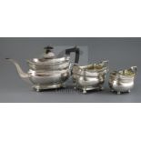 A matched George III silver three piece tea set, of rounded rectangular form, with reeded shoulders,