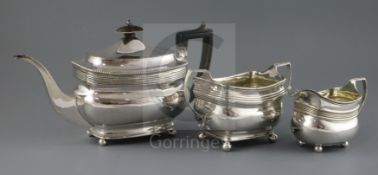 A matched George III silver three piece tea set, of rounded rectangular form, with reeded shoulders,