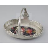 A rare Moorcroft 'pomegranate' inset Tudric pewter cake basket, c.1920, designed by Archibald