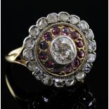 An 18ct gold, ruby and diamond target cluster ring, the central diamond measuring approximately 5.