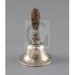 A 19th century continental silver hand bell, with engraved scroll decoration and carved wood?