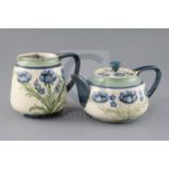 A Moorcroft Macintyre 'blue poppy' teapot and matching milk jug, Rd. no. for 1905, decorated with