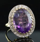 A large gold, amethyst and diamond set oval dress ring, the oval cut amethyst bordered by twenty