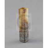 A Chinese archaistic white and russet jade handle mount, carved in relief with three registers of