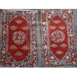 A near pair of Tibetan red ground rugs, woven with central medallions, spandrels and peony meander