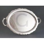 A George V silver two handled shaped oval tea tray, William Suckling Ltd, on four scroll feet,