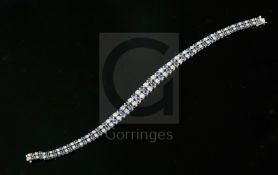 A 20th century 14ct white gold, graduated sapphire and diamond twin line bracelet, set with one