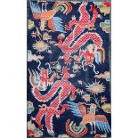 A Tibetan 'dragon' rug, woven with two confronting dragons, cockerels and stylised foliage, c.