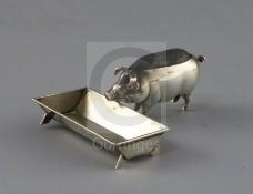 An Edwardian novelty silver pin cushion, modelled as a pig at a trough, by Adie & Lovekin,