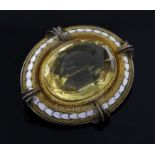 A Victorian gold, white enamel and citrine set oval brooch, the large oval cut stone with gold multi