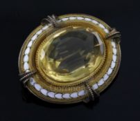 A Victorian gold, white enamel and citrine set oval brooch, the large oval cut stone with gold multi