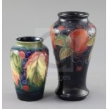 A Moorcroft 'pomegranate' vase and a 'leaf and berry' vase, 1930's, the tallest with a cobalt blue