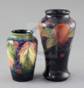 A Moorcroft 'pomegranate' vase and a 'leaf and berry' vase, 1930's, the tallest with a cobalt blue