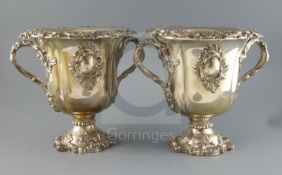 An ornate pair of 19th century Old Sheffield plate two handled pedestal wine coolers, with removable