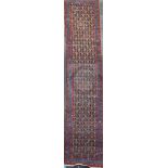 An antique Azerbaijan runner, with field of stylised flowers, on a red ground, with three row