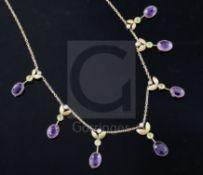 An Edwardian 15ct gold, amethyst, peridot and seed pearl set drop necklace, 40cm.