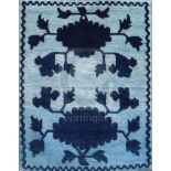 A Tibetan saddle seat rug, woven with black stylised peonies, in silhouette, against a silver field,