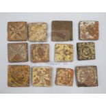 Twelve medieval terracotta tiles, ten with encaustic decoration, ranging from 10.4 -13cm wide