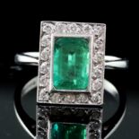 An Art Deco style 18ct white gold, emerald and diamond tablet cluster ring, size O.