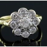 A modern 18ct gold and nine stone diamond flowerhead cluster ring, size J.