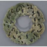 A Chinese archaistic celadon jade disc, carved and pierced with interlaced chilong, D. 23.2cm