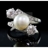 A modern white gold, natural pearl and two stone diamond crossover ring with diamond set
