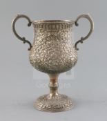 An early 20th century Indian Kutch silver two handled pedestal cup, embossed with scrolling foliage,