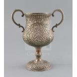 An early 20th century Indian Kutch silver two handled pedestal cup, embossed with scrolling foliage,