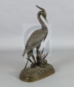 After Jules Moigniez. A bronze model of a heron, standing on a naturalistic base, signed in the