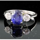 An 18ct white gold, sapphire and diamond three-stone ring, size N.