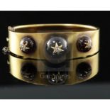 A Victorian gold, three graduated cabochon garnet and diamond set hinged bracelet, each stone with