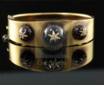 A Victorian gold, three graduated cabochon garnet and diamond set hinged bracelet, each stone with