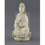 A Chinese Dehua blanc de chine figure of Guanyin, seated holding a jewel and a vase, on a lotus