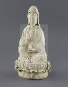 A Chinese Dehua blanc de chine figure of Guanyin, seated holding a jewel and a vase, on a lotus