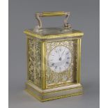 An early 20th century silvered and ormolu hour repeating carriage clock, with enamelled Roman dial