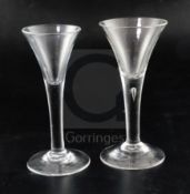 Two drawn trumpet wine glasses, c.1750, the larger example with tear drop to the plain stem, on a