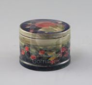 A Moorcroft 'pomegranate' pattern drum shaped box and cover, c.1918-26, with metal mounted rim,