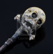 A 19th century French? base metal and cream enamel skull head stick pin, in the manner of Trouve &