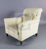 A Howard and Sons club armchair, with buttoned back upholstery and squared legs, on brass castors