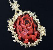 A modernist gold and carved coral oval pendant, with branch-effect mount on gold chain (tests as