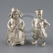 A pair of late 19th century Hanau silver figural pepperettes, modelled as a Dutch? boy and girl,