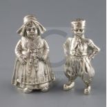 A pair of late 19th century Hanau silver figural pepperettes, modelled as a Dutch? boy and girl,