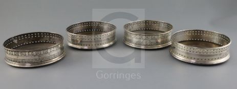 A set of four George III pierced silver wine coasters, probably Robert & David Hennell, with