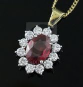 An 18ct gold and platinum ruby and diamond cluster pendant on 18ct gold fine chain, pendant 12mm.